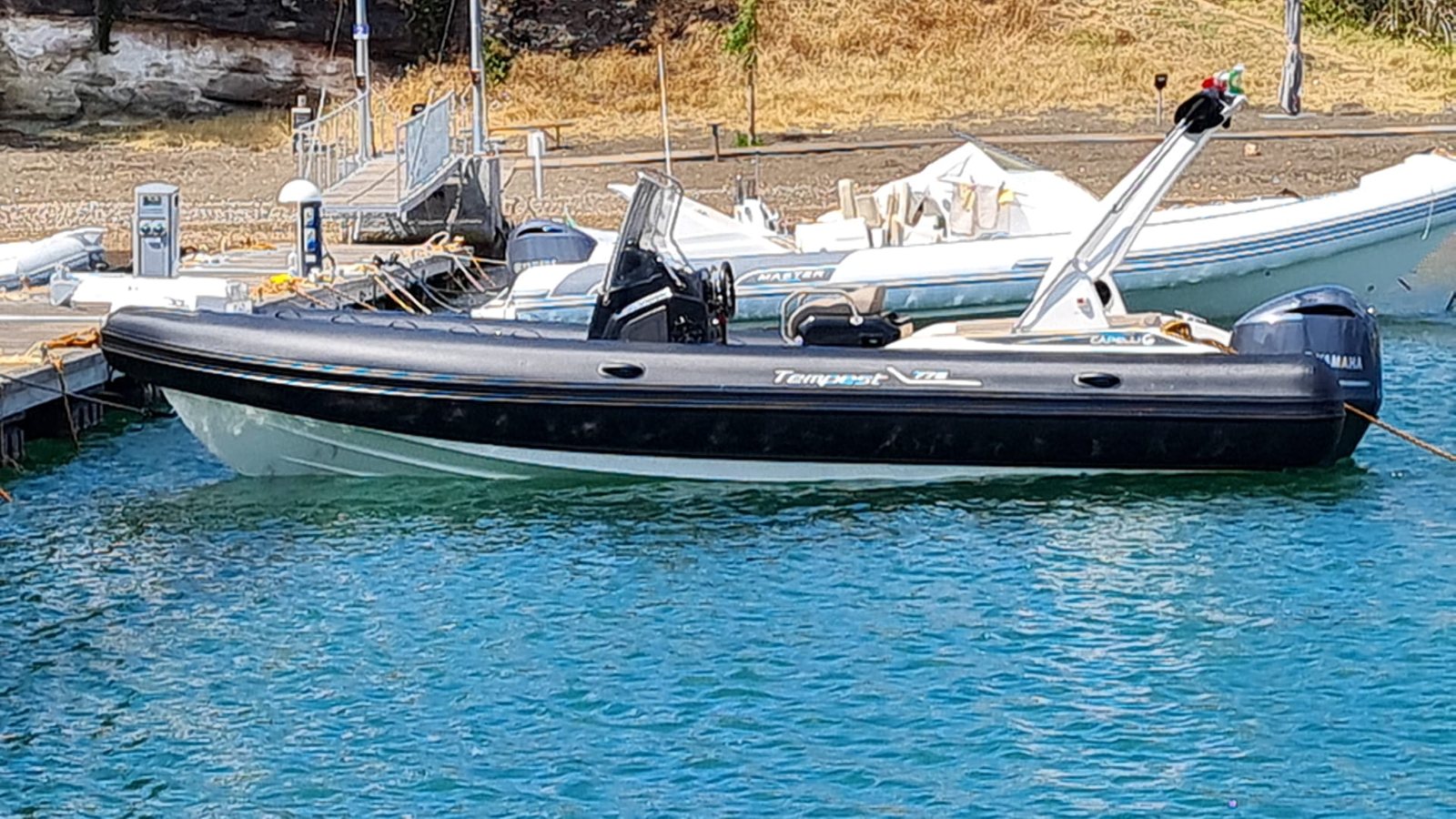 Gommone nero Capelli Tempest con motore Yamaha, ormeggiato al pontile accanto ad altre barche